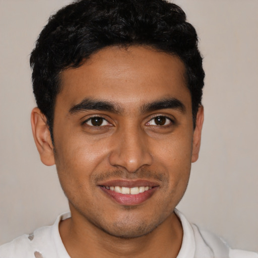 Joyful latino young-adult male with short  black hair and brown eyes