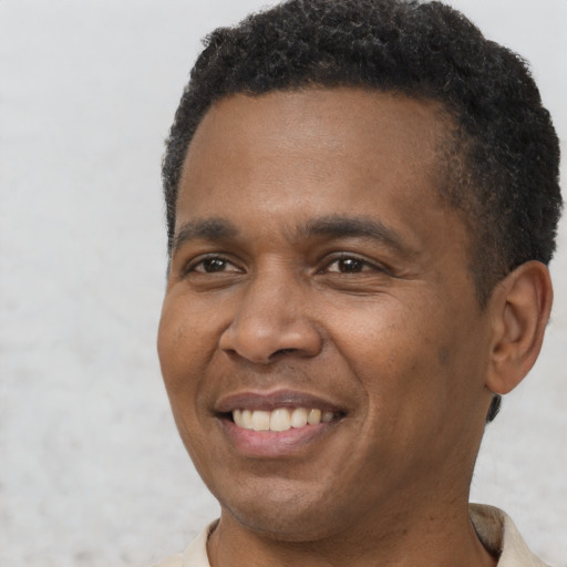 Joyful black adult male with short  brown hair and brown eyes