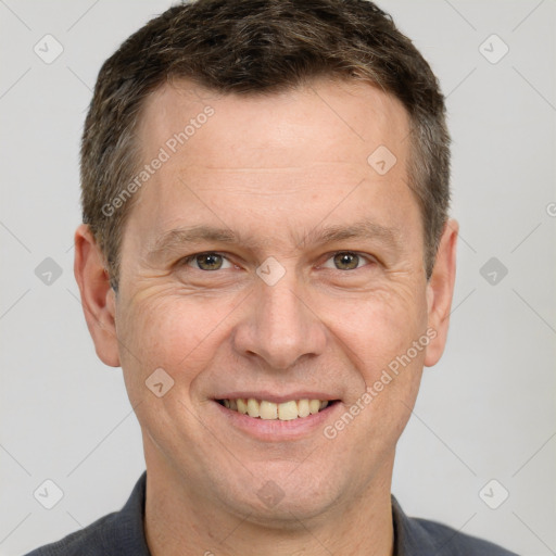 Joyful white adult male with short  brown hair and brown eyes