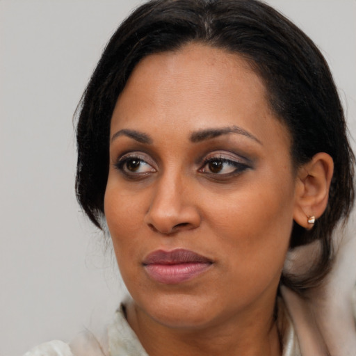 Joyful black young-adult female with medium  brown hair and brown eyes