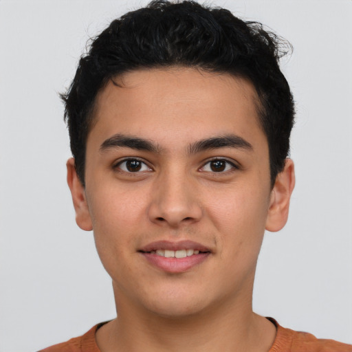 Joyful latino young-adult male with short  brown hair and brown eyes