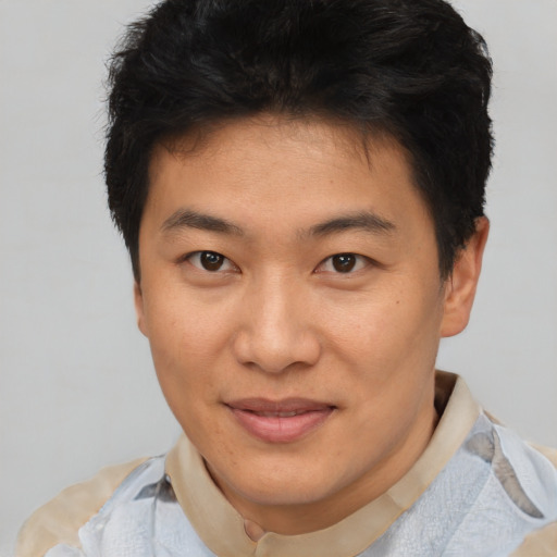 Joyful asian young-adult male with short  brown hair and brown eyes