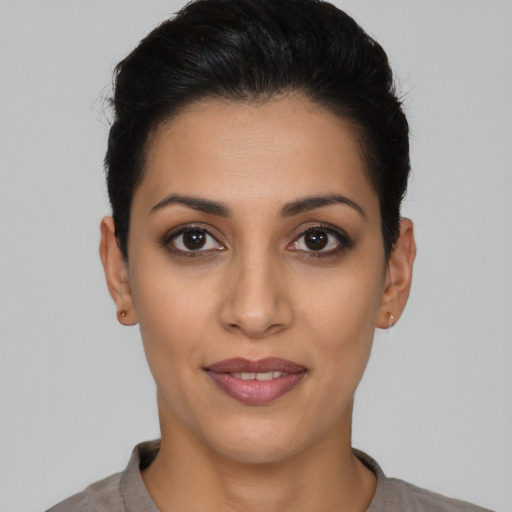 Joyful latino young-adult female with short  black hair and brown eyes