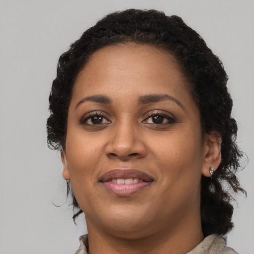 Joyful black young-adult female with medium  black hair and brown eyes