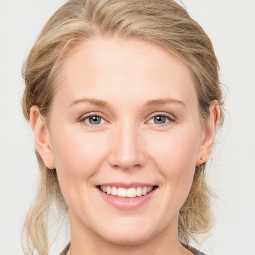 Joyful white young-adult female with medium  brown hair and blue eyes