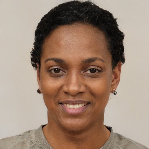 Joyful black young-adult female with short  black hair and brown eyes
