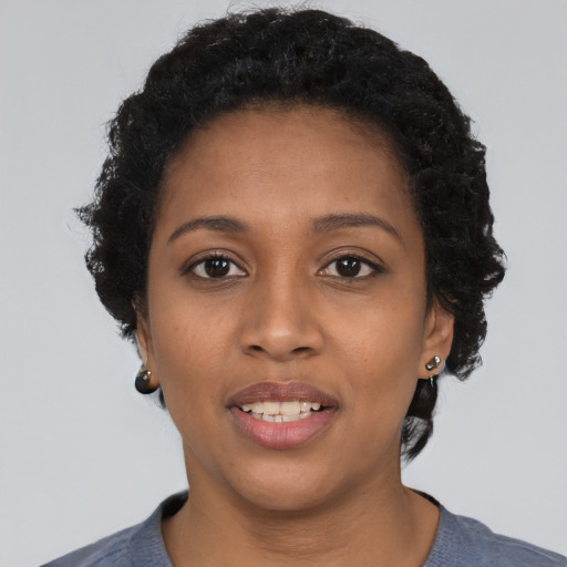 Joyful black young-adult female with short  black hair and brown eyes