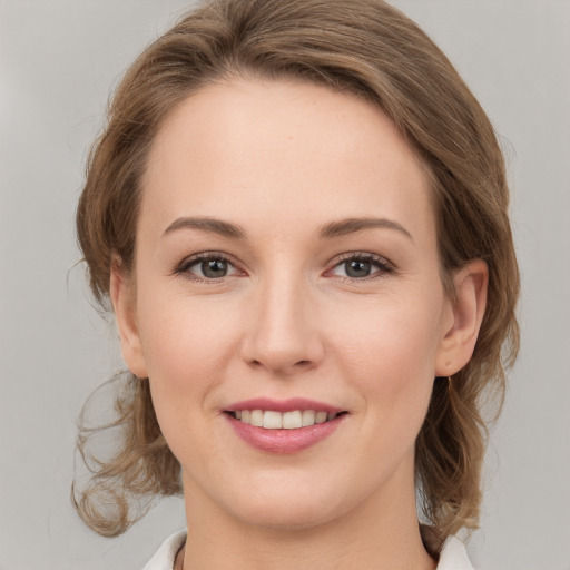 Joyful white young-adult female with medium  brown hair and grey eyes