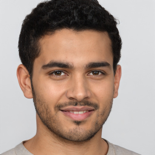 Joyful latino young-adult male with short  brown hair and brown eyes