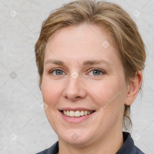 Joyful white adult female with medium  brown hair and blue eyes