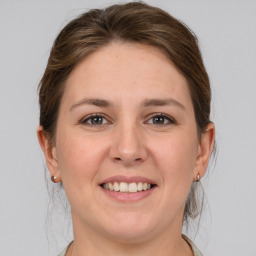 Joyful white young-adult female with medium  brown hair and grey eyes