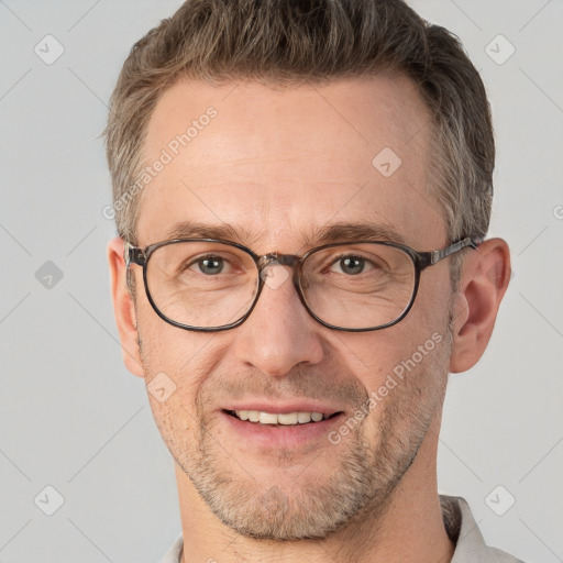 Joyful white adult male with short  brown hair and grey eyes