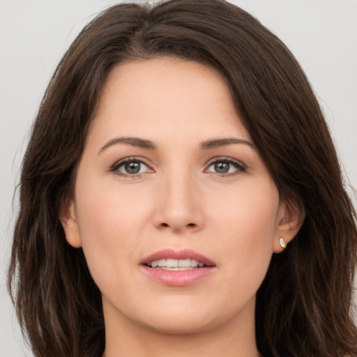 Joyful white young-adult female with long  brown hair and brown eyes