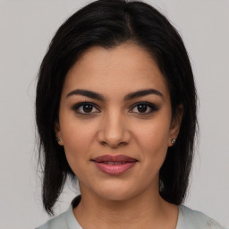 Joyful latino young-adult female with medium  brown hair and brown eyes