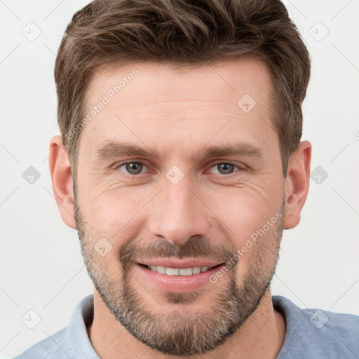 Joyful white young-adult male with short  brown hair and grey eyes