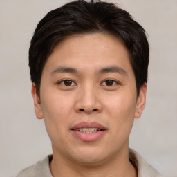 Joyful asian young-adult male with short  brown hair and brown eyes