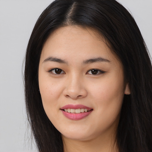 Joyful asian young-adult female with long  brown hair and brown eyes