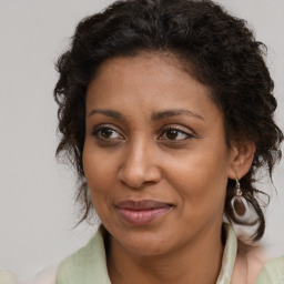 Joyful black young-adult female with medium  brown hair and brown eyes