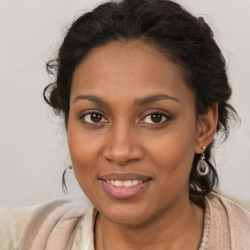 Joyful black young-adult female with long  brown hair and brown eyes