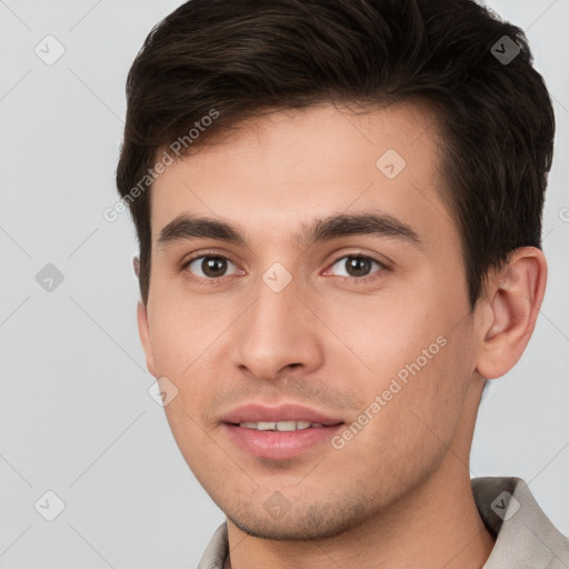 Joyful white young-adult male with short  brown hair and brown eyes