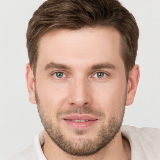 Joyful white young-adult male with short  brown hair and grey eyes