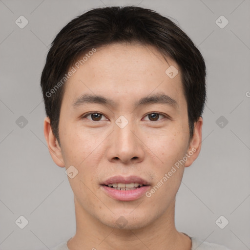 Joyful asian young-adult male with short  brown hair and brown eyes