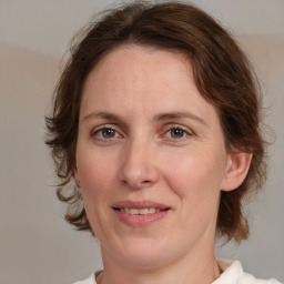 Joyful white adult female with medium  brown hair and grey eyes