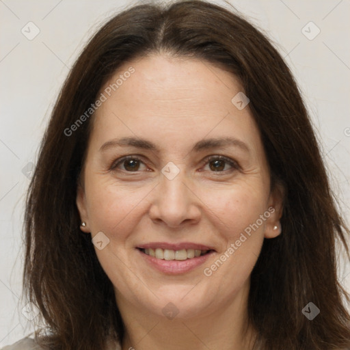 Joyful white adult female with long  brown hair and brown eyes