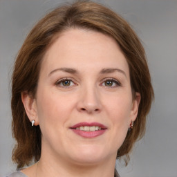 Joyful white young-adult female with medium  brown hair and grey eyes