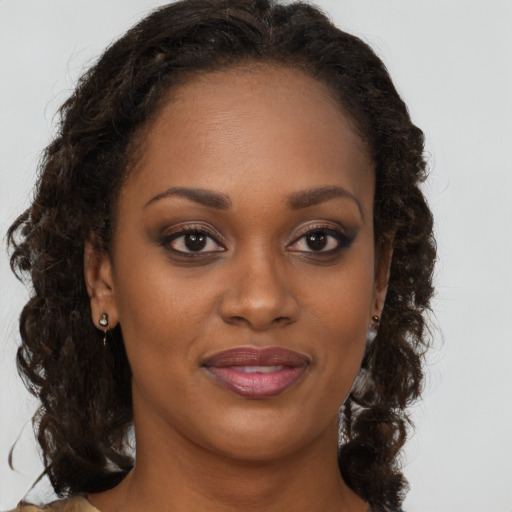 Joyful black young-adult female with long  brown hair and brown eyes