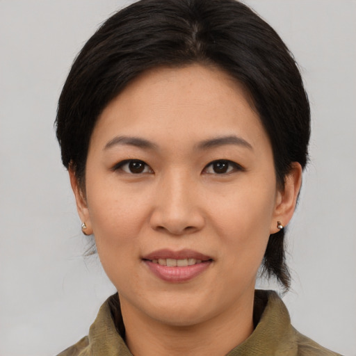 Joyful asian adult female with medium  brown hair and brown eyes