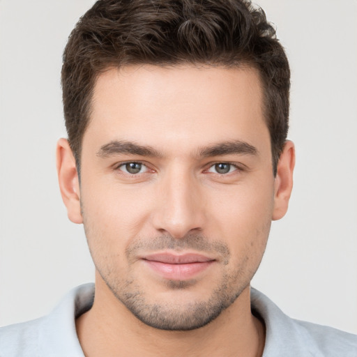 Joyful white young-adult male with short  brown hair and brown eyes