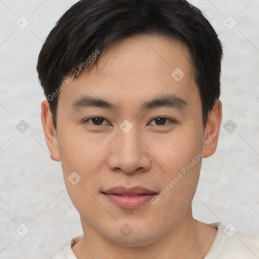 Joyful asian young-adult male with short  brown hair and brown eyes