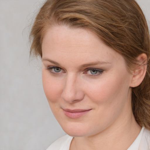 Joyful white young-adult female with long  brown hair and blue eyes