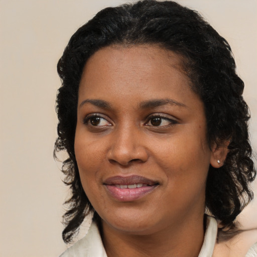 Joyful black young-adult female with medium  black hair and brown eyes