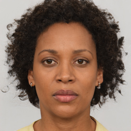 Joyful black adult female with short  brown hair and brown eyes