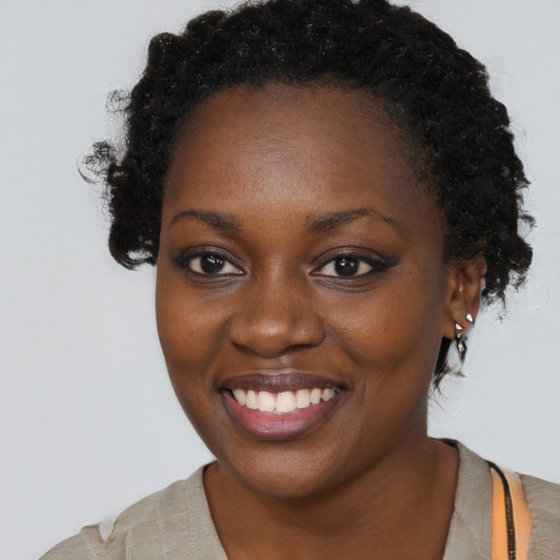 Joyful black young-adult female with short  brown hair and brown eyes