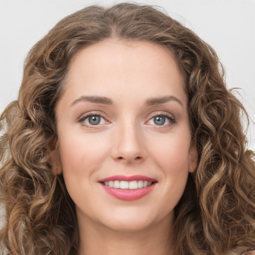 Joyful white young-adult female with long  brown hair and green eyes