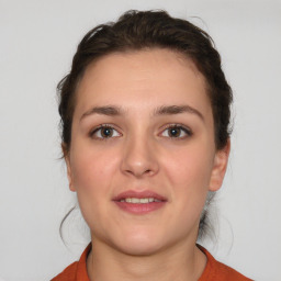 Joyful white young-adult female with medium  brown hair and grey eyes