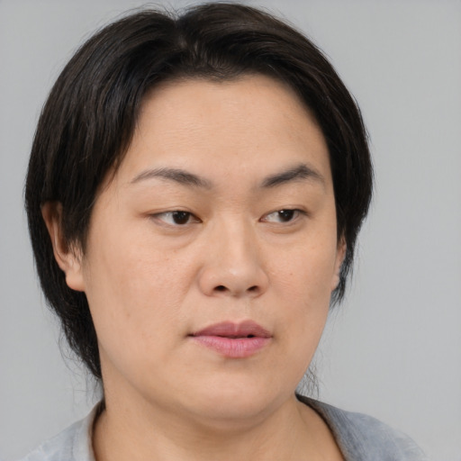 Neutral asian adult female with medium  brown hair and brown eyes