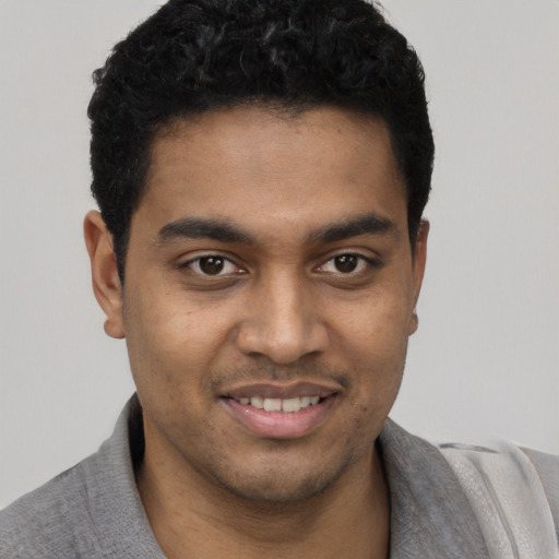 Joyful black young-adult male with short  black hair and brown eyes