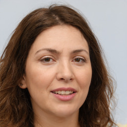 Joyful white adult female with long  brown hair and brown eyes