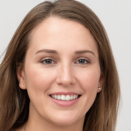 Joyful white young-adult female with long  brown hair and grey eyes