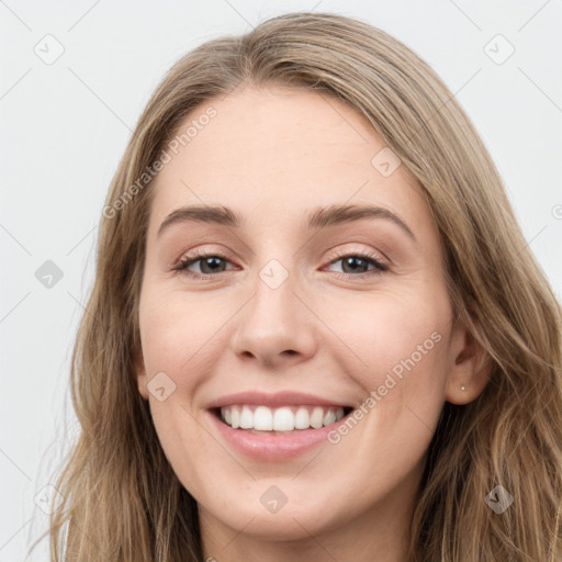 Joyful white young-adult female with long  brown hair and blue eyes