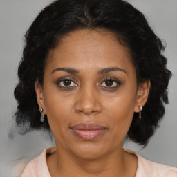 Joyful latino adult female with medium  brown hair and brown eyes
