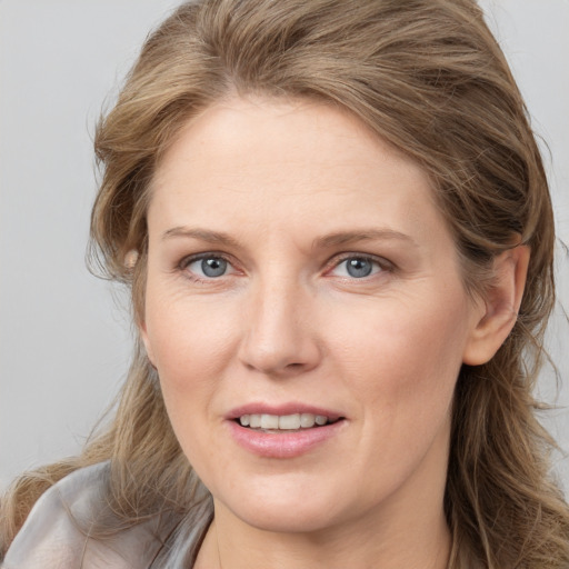 Joyful white adult female with medium  brown hair and grey eyes