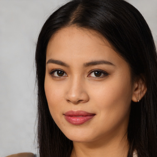 Joyful latino young-adult female with long  black hair and brown eyes