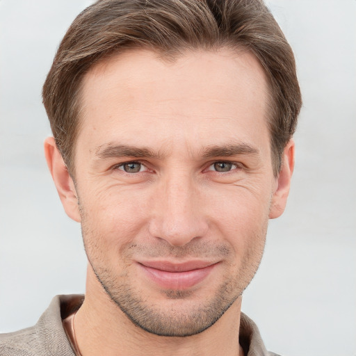 Joyful white young-adult male with short  brown hair and grey eyes