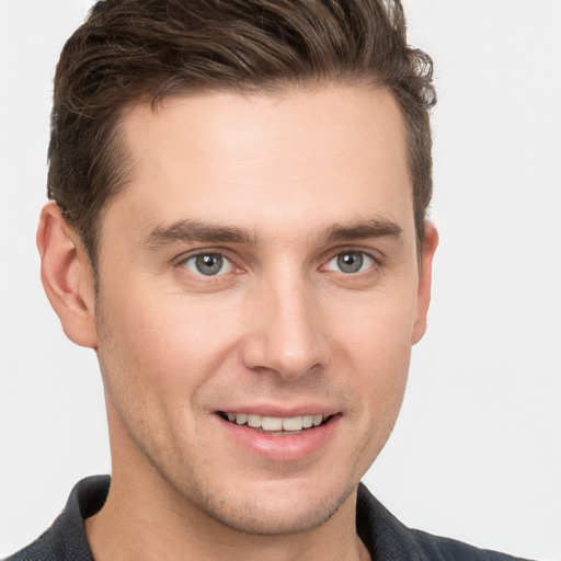 Joyful white young-adult male with short  brown hair and grey eyes