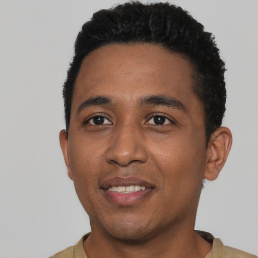 Joyful black young-adult male with short  black hair and brown eyes